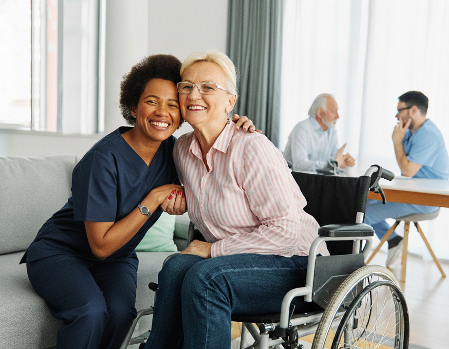 Caregiver with client smiling on sofa